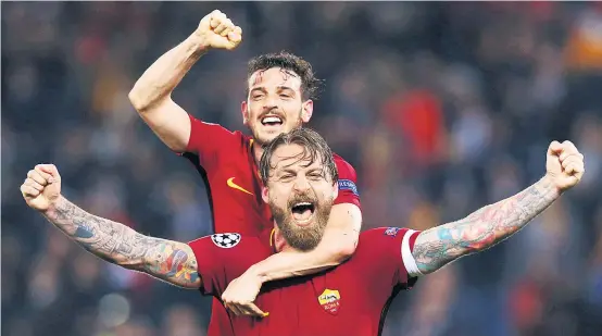  ??  ?? Der Schrei nach dem historisch­en Spiel: Romas reich verzierter Kapitän Daniele De Rossi schultert den Kollegen Alessandro Florenzi.