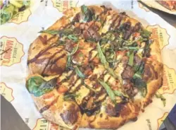  ?? PHOTOS BY SARA JACKSON ?? The Steak &amp; Blue pizza has garlic olive oil, grilled steak, mozzarella, blue cheese, tomatoes, spinach, basil and a drizzle of balsamic glaze.