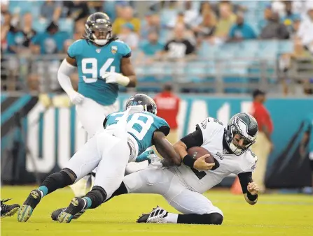  ?? PHELAN M. EBENHACK/AP ?? Eagles quarterbac­k Cody Kessler takes a hit from Jaguars defensive back C.J. Reavis early in Thursday’s game. Kessler left with a possible concussion before the first series of the game had even ended.