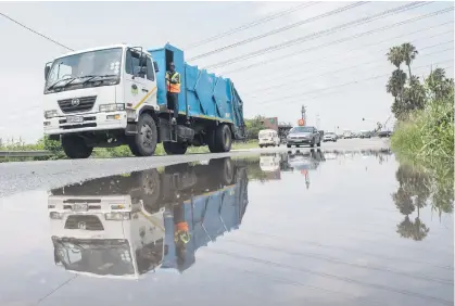  ?? Picture: Michel Bega ?? GIANT PUDDLE. A refuse truck and other vehicles avoid a large pool of water on Witkoppen Road, northern Joburg, yesterday after heavy rain battered Gauteng.