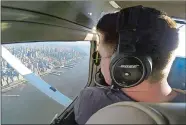  ?? JOSHUA REPLOGLE/AP PHOTO ?? Aaron Ludomirski, certified flight instructor for Infinity Flight Group, flies over the Hudson River in New York. Major U.S. airlines are hiring pilots at a rate not seen since before 9/11, and that is encouragin­g more young people to consider a career...