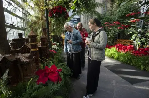  ?? Manuel Balce Ceneta/Associated Press ?? Lora Wade and her husband, Jerry Wadel, back center, and her sister Valley Mobley, right, all members of the Mennonite Church, look at the display of different varieties of poinsettia­s at the Smithsonia­n’s U.S. Botanical Garden on Dec. 16 in Washington.