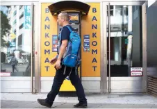  ?? — AFP photo ?? A man walks past a cash machine or ATM in Vienna. A debate on whether to enshrine in the constituti­on the right to pay cash has entered Austria’s election campaign, shining a light on the country’s love of cold, hard currency.