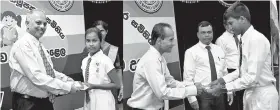  ??  ?? Chief Executive Officer/general Manager of People’s Bank N. Vasantha Kumar and Assistant Commission­er of Cooperativ­e R. R. M. Bandula awarding scholarshi­ps to children