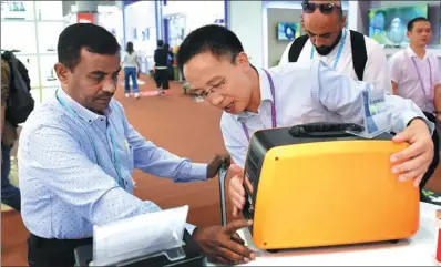  ?? LU HANXIN / XINHUA ?? A customer looks at an oven at the 121st China Import and Export Fair in Guangzhou, Guangdong province on Saturday. The spring Canton Fair, which opened on that day, is China’s largest trade fair, attracting entreprene­urs from around the world.