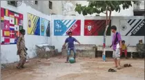  ?? AFP ?? Kids in Karachi, Pakistan, play soccer last week in front of a mural depicting the teams competing at the 2022 FIFA World Cup in Qatar.