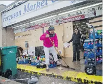  ?? DAVID GOLDMAN/ THE ASSOCIATED PRESS ?? Anjana Patel cleans up the damage from Monday’s riots at her store on Wednesday in Ferguson.