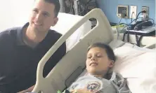  ?? John Shea / The Chronicle ?? Giants catcher Buster Posey visits Remy Koks, an 11-year-old Houston Astros fan, at Texas Children’s Cancer Center.