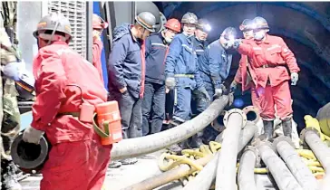  ?? XINHUA ?? WORKERS set up equipment on Sunday to rescue 21 miners still trapped since Saturday in a coal mine in Hutubi county, Xinjiang Uygur Autonomous Region.