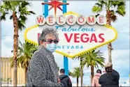  ?? PHOTOS BY DAVID BECKER FOR THE WASHINGTON POST ?? Bertha Lopez of Mexico, above, wears a face mask as she visits the “Welcome to Las Vegas” sign. Top, storm clouds hover over he Las Vegas Strip.