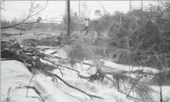  ??  ?? A man rides a bicycle next to a flooded road after the area was hit by Hurricane Maria in Guayama, Puerto Rico September 20, 2017. REUTERS/Carlos Garcia Rawlins By 8 p.m. EDT (midnight GMT), Maria’s center was drifting away from