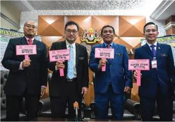  ?? — Bernama photo ?? Chong (second le ) and the ministry chief secretary Datuk Muez Abd Aziz (third le ) hold the price tags of some controlled items at the press conference.