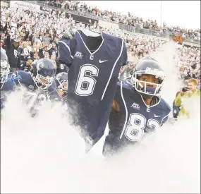  ?? Hearst Connecticu­t Media file photo ?? UConn’s Kashif Moore carries out the jersey of murdered teammate Jasper Howard before a game against Rutgers in 2009.