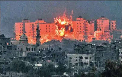  ?? ?? DESTRUCCIó­N. Palestinos tras uno de los bombardeos israelíes, que acumula fuerzas en la frontera.