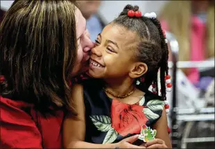  ?? DAVID CARSON/ST. LOUIS POST-DISPATCH/TNS ?? Mary Thomas gives a kiss to her newly adopted daughter, 4-year-old Hanzi Thomas, during a hearing in a St. Louis County courtroom on Nov. 18. Thirty children had their adoptions finalized as part of the county’s first National Adoption Day event since 2015. The day is celebrated on the Saturday before Thanksgivi­ng.