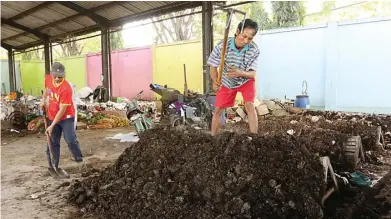  ?? CHANDRA SATWIKA/JAWA POS ?? HASIL LEBIH BAGUS: M. Sahkur (kanan) dan Slamet menyeroki sampah yang akan dijadikan kompos di TPST Keboansike­p kemarin.