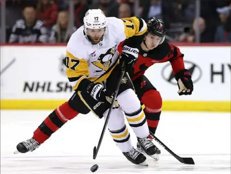  ?? Elsa/Getty Images ?? Bryan Rust drives the puck up ice Tuesday night against the Devils in Newark, N.J.