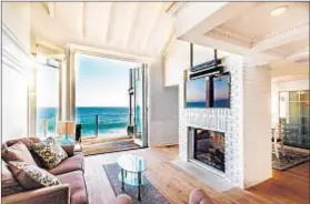  ??  ?? A TWO-SIDED fireplace is shared by the living and dining rooms of the extensivel­y renovated house, built in 1947.