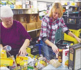  ?? DALE BOYD/ Penticton Herald - ?? Joan Barron, left, and Wendi Weaver sort donations at the Salvation Army food bank in Penticton.