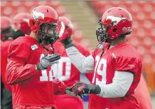  ?? COLLEEN DE NEVE/ CALGARY HERALD ?? Stampeders linebacker Juwan Simpson, left, and defensive lineman Charleston Hughes greet each other with a special handshake during practice on Thursday. They'll see another old friend in Winnipeg offensive lineman Stanley Bryant on Saturday.