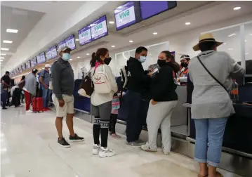  ?? ( Henry Romero/ Reuters) ?? TOURISTS QUEUE at airline counters before departing from Cancun’s internatio­nal airport in Mexico last week.