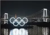  ?? CARL COURT Getty Images/TNS ?? The Olympic Rings are alight in Tokyo, Japan. The global event, after being delayed for a year, gets underway with the Opening Ceremony July 23.