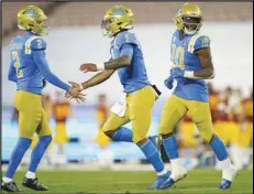  ?? Associated Press ?? LAST GAME — UCLA running back Demetric Felton, right, celebrates a touchdown with placekicke­r Nicholas Barr-Mira (2) and quarterbac­k Dorian Thompson-Robinson (1) during the second quarter against USC on Dec 12 in Pasadena. UCLA takes on Stanford today in the season finale for both teams.
