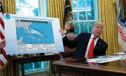  ??  ?? Donald Trump presents an official government weather map altered with a Sharpie to change the projected path of Hurricane Dorian. Photograph: Rex/Shuttersto­ck