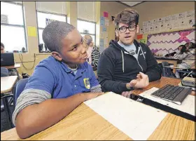  ?? PHOTOS / JCRAWFORD@AJC. COM
JOHNNY CRAWFORD ?? Myles Dunn, 11, tries to think of a name as he works with Drew Muldowney at KIPP Strive Academy earlier this month.