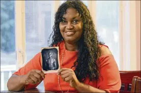  ?? JOHN SHISHMANIA­N / THE NORWICH BULLETIN ?? Tamara Lanier holds an 1850 photograph of Renty, a South Carolina slave who Lanier said is her family’s patriarch. The portrait was commission­ed by Harvard biologist Louis Agassiz, whose ideas were used to support slavery.