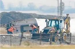  ?? TED S. WARREN/AP ?? Workers clear debris two days after an Amtrak train derailed Sept. 25, 2021, near Joplin, Mont. Three passengers died and two others were seriously injured in the crash.