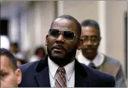  ?? MATT MARTON — THE ASSOCIATED PRESS FILE ?? R. Kelly, center, leaves the Daley Center after a hearing in his child support case May 8, 2019, in Chicago.