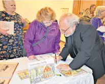  ?? DESIREE ANSTEY/JOURNAL PIONEER ?? Summerside artist Eddie Schwartz signs copies of his new book at the recent re-opening of the Eptek Art and Culture Centre.