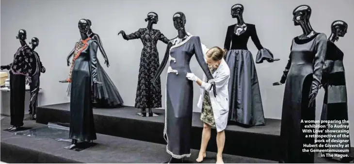  ??  ?? A woman preparing the exhibition ‘To Audrey With Love’ showcasing a retrospect­ive of the work of designer Hubert de Givenchy at the Gemeentemu­seum in The Hague.