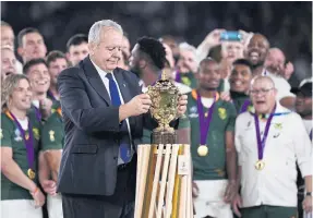  ??  ?? World Rugby chairman Bill Beaumont lifts the Webb Ellis Cup to hand it to world champions South Africa.