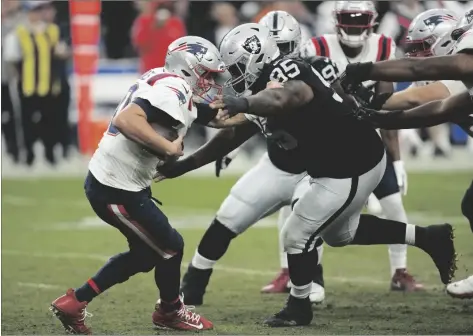  ?? AP PHOTO/JOHN LOCHER ?? Las Vegas Raiders defensive tackle John Jenkins (right) sacks New England Patriots quarterbac­k Mac Jones during the second half of an NFL football game on Sunday in Las Vegas.