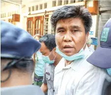  ?? photo — AFP ?? Nay Myo Lin is escorted from his home by police to court in Mandalay.