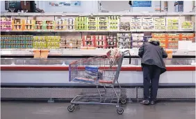  ?? LUKE SHARRETT/BLOOMBERG ?? A shopper browses a refrigerat­ed food case at a Costco in Louisville, Kentucky.