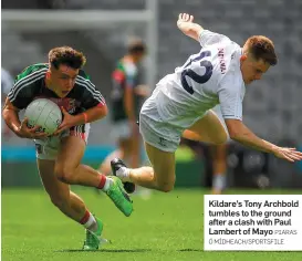  ?? PIARAS Ó MÍDHEACH/SPORTSFILE ?? Kildare’s Tony Archbold tumbles to the ground after a clash with Paul Lambert of Mayo