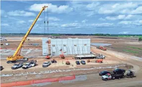  ?? JIM NELSON AND MIKE DE SISTI / MILWAUKEE JOURNAL SENTINEL ?? A crane erects a structure on the Foxconn site just north of First Street and west of Racine County Road H as constructi­on is underway for Foxconn Technology Group’s planned $10 billion electronic­s factory complex in Mount Pleasant.