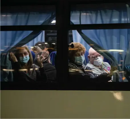  ?? GETTY IMAGES ?? COMING TO AMERICA: American citizens wave from a bus as they leave the quarantine­d Diamond Princess cruise ship to be repatriate­d to the United States on Monday in Yokohama, Japan.