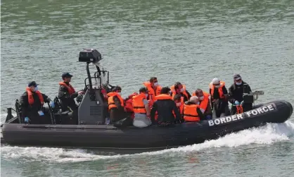  ?? Photograph: Gareth Fuller/PA ?? A group of people being brought into Dover, Kent, by Border Force officers on Tuesday.