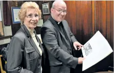  ?? JOE BARKOVICH/SPECIAL TO THE TRIBUNE ?? Holy Trinity parish council member Eileen Zarafoniti­s and Rev. Tom Vaughan glance through a commemorat­ive anniversar­y book from the Anglican church’s long history in Welland.
