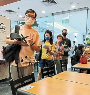  ?? ?? Bring it home safe: malaysian voters in singapore handing over their ballot papers to a group of volunteers on the island republic, who will later send it back home for the election.