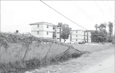  ??  ?? The Police Compound on Mandela Avenue lost its fence over three months ago; the section which collapsed has remained in the drain while the other rotted portion hangs in the balance.