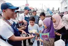  ??  ?? WAKIL minuman teh gaya hidup Tealive mengagihka­n minuman kepada murid.