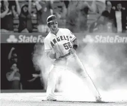  ?? Associated Press ?? n Los Angeles Angels’ Kole Calhoun celebrates after scoring a run on a single by Albert Pujols on Sunday during the ninth inning against the Seattle Mariners in Anaheim, Calif.