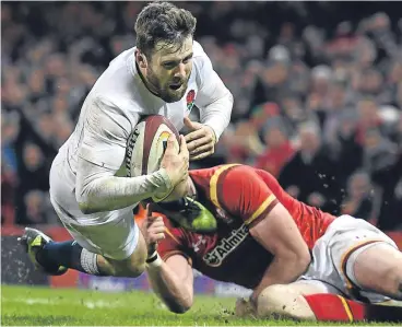  ??  ?? Elliot Daly dives past Alex Cuthbert of Wales to score the winning try yesterday.