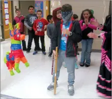  ?? Westside Eagle Observer/SUSAN HOLLAND ?? Students line up and wait their turn at striking the pinata at the GUE multicultu­ral dinner Thursday, April 5, as one blindfolde­d young man prepares to take a whack at the colorful, candy-filled donkey.