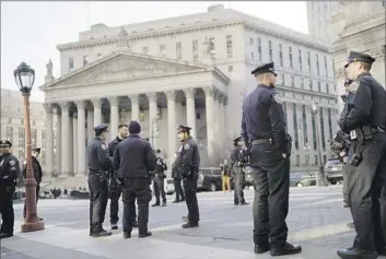  ?? Eduardo Munoz Alvarez Associated Press ?? POLICE STAND BY outside court in New York on Tuesday. Officials were monitoring online chatter for threats ahead of expected criminal charges against ex-President Trump over alleged hush money payments.